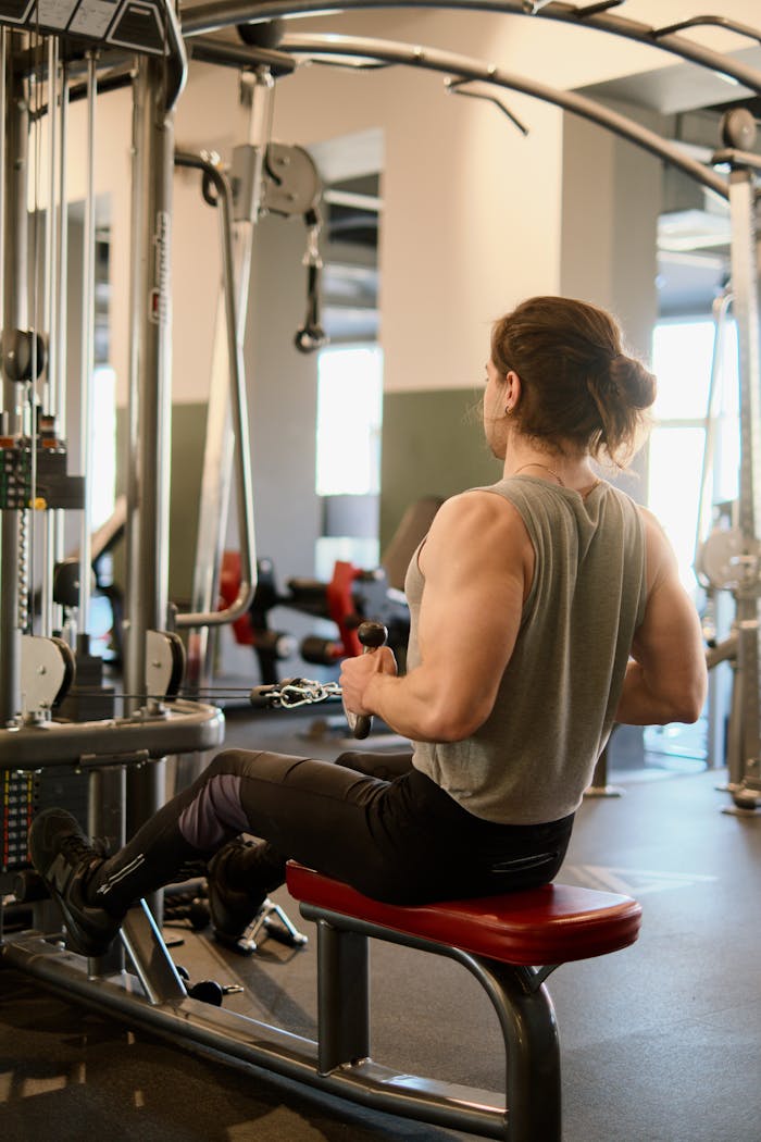 A man exercises on gym equipment, focusing on strength training and fitness.